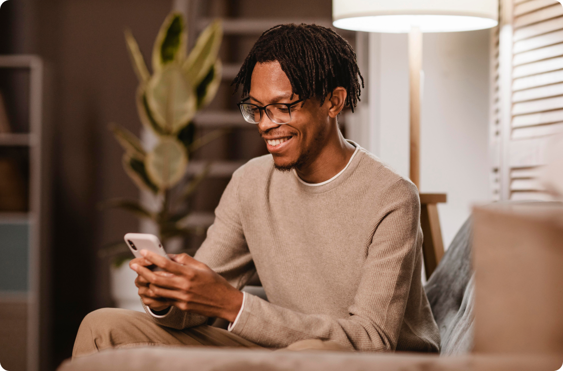 homem negro sorrindo com celular